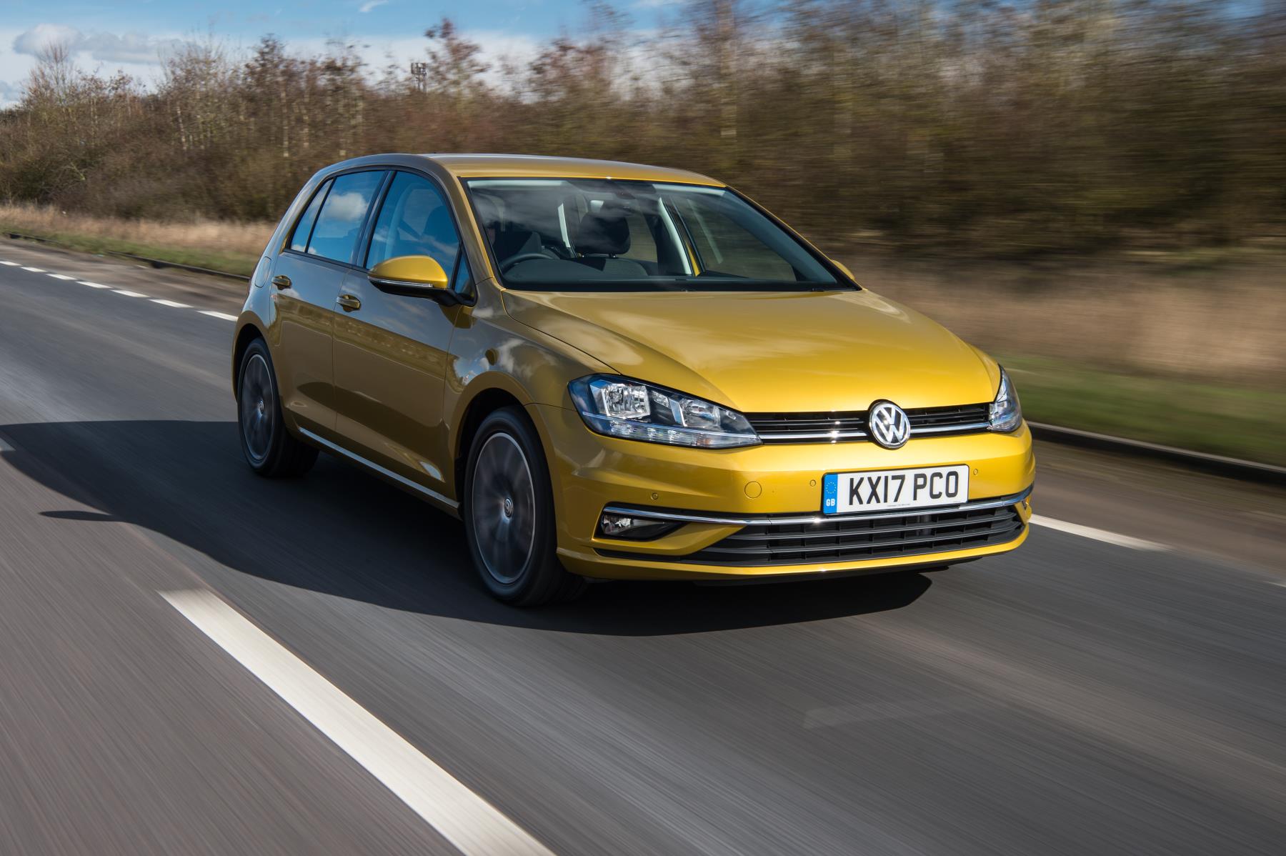 Yellow Volkswagen Golf driving on road
